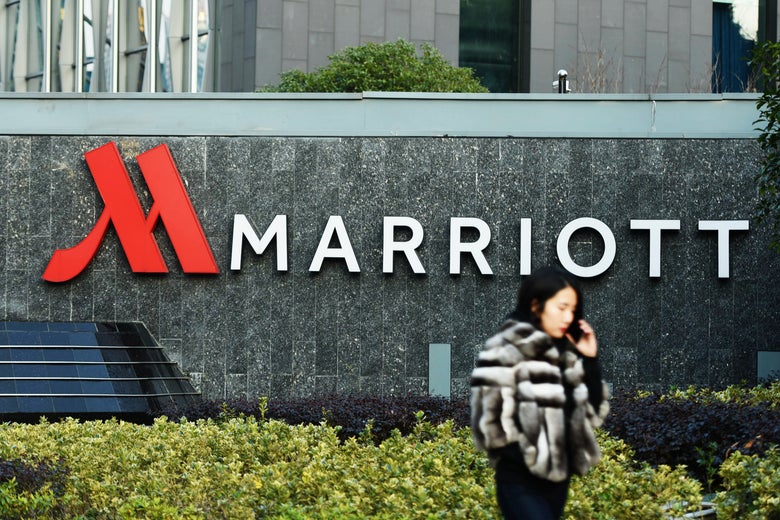 Woman walking past Marriott sign.